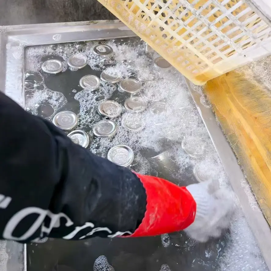 Stainless steel mug components being washed during production