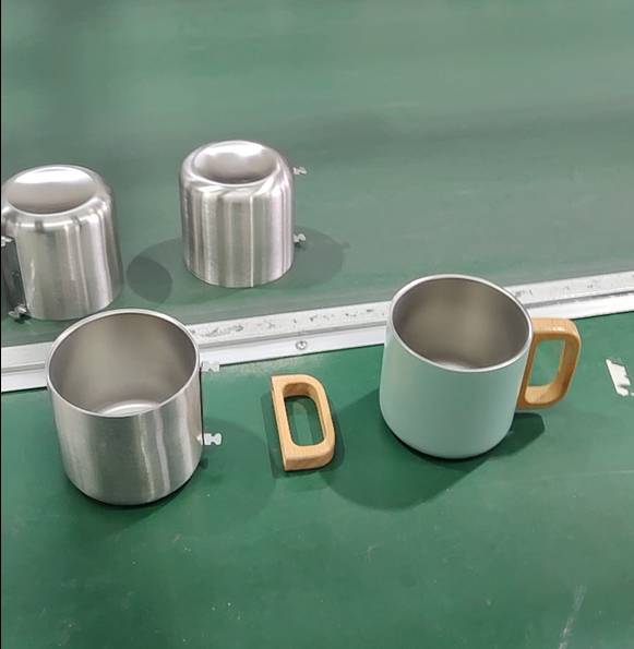 Custom stainless steel mug assembly stages with welded metal inserts and wooden handle